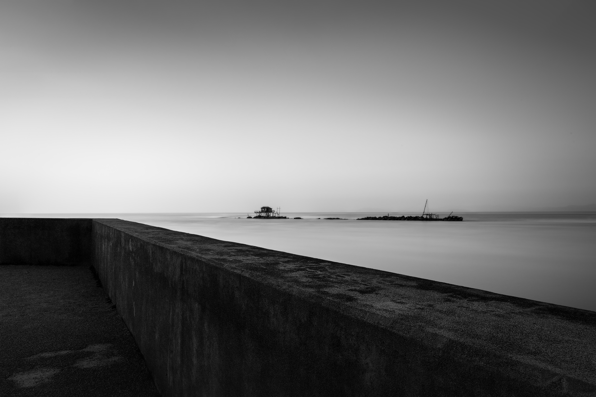 fotografia minimalista, bianco e nero, lunga esposizione, paesaggio marino, silenzio, fotografia artistica, atmosfera contemplativa.