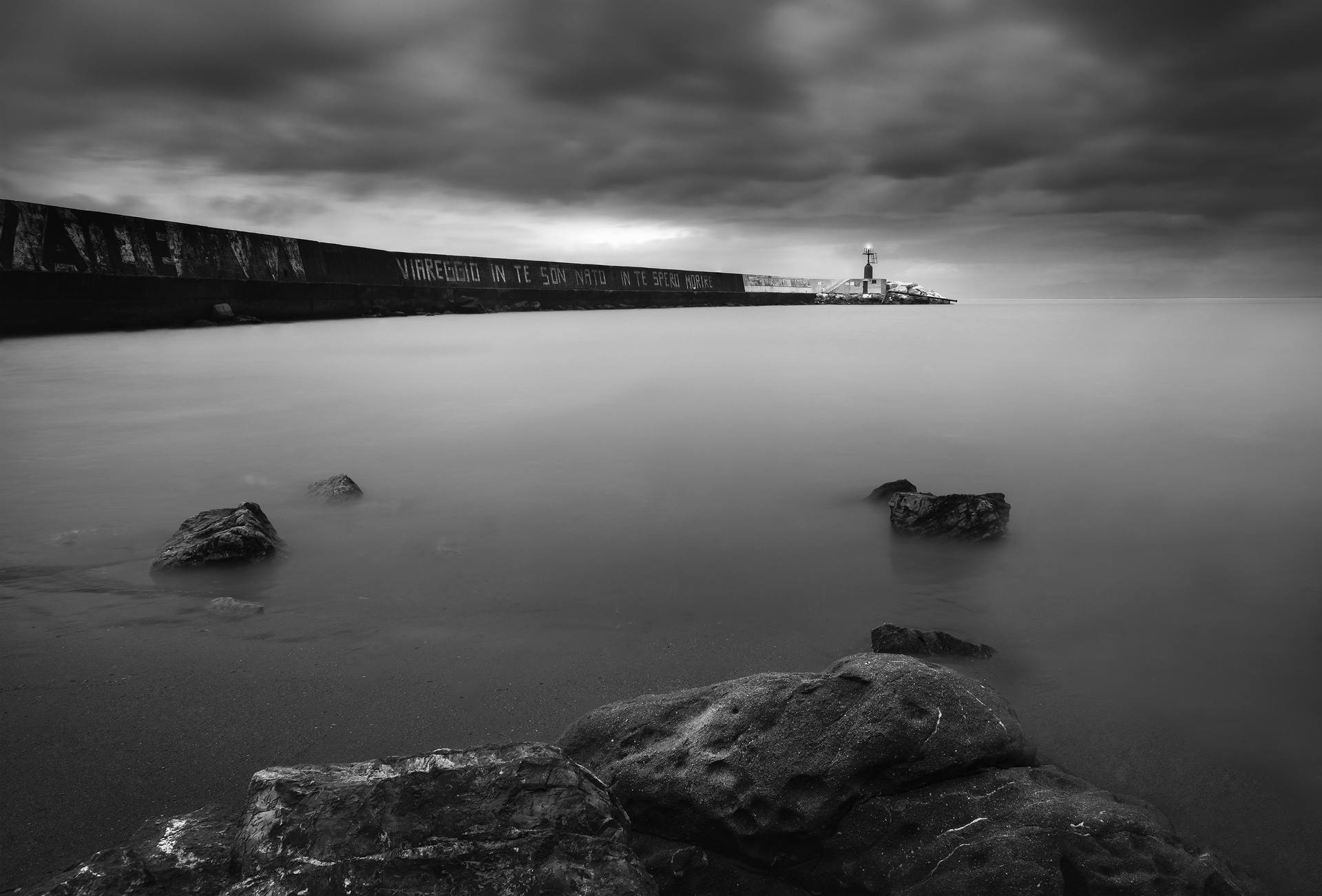 Fotografia in bianco e nero del porto di Viareggio con il molo e il faro al tramonto, tecnica di focus stacking.