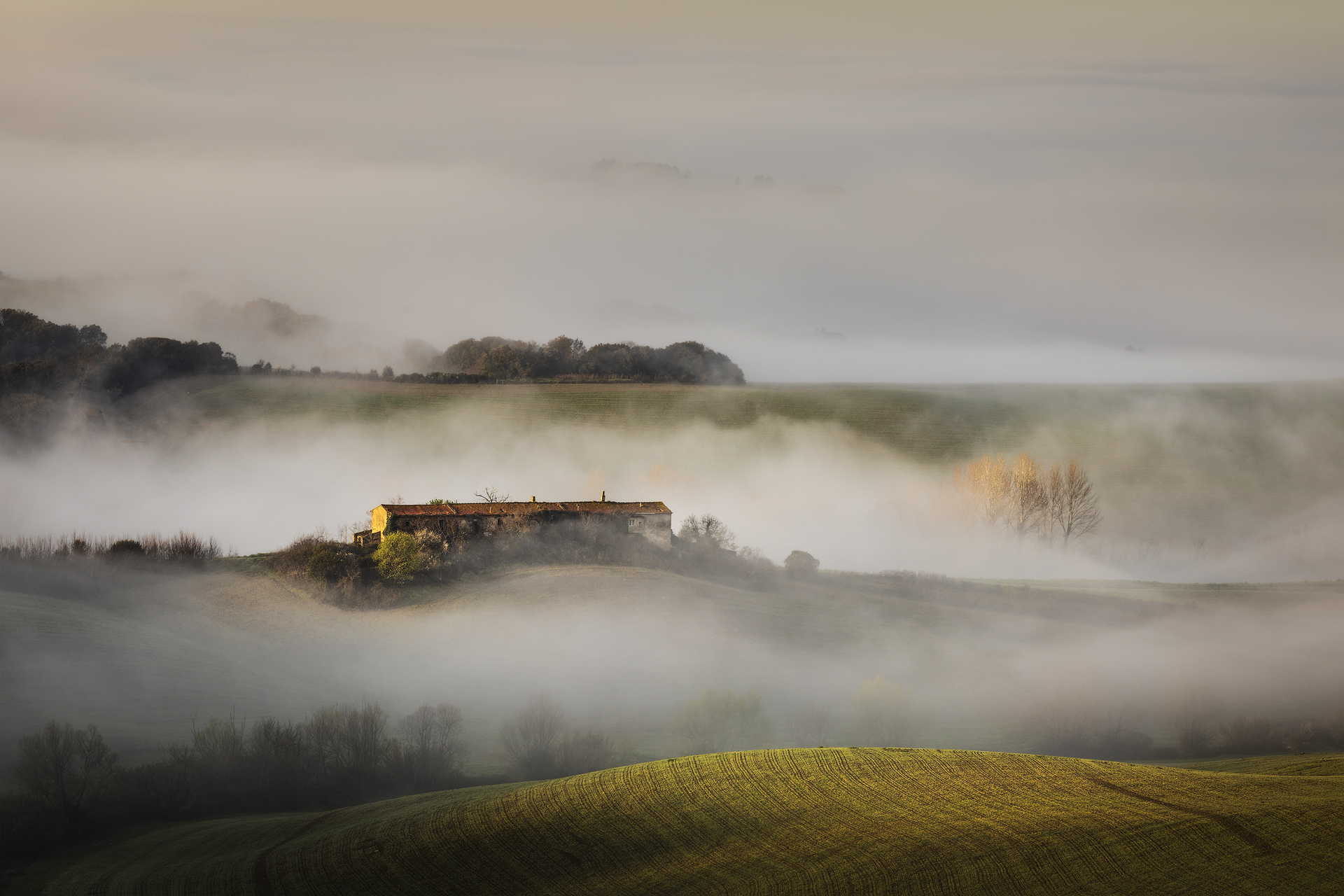 Casolare tra le colline avvolto dalla nebbia all’alba nei pressi del Santuario Madonna dei Monti, Casciana Terme Lari, Pisa, Italia